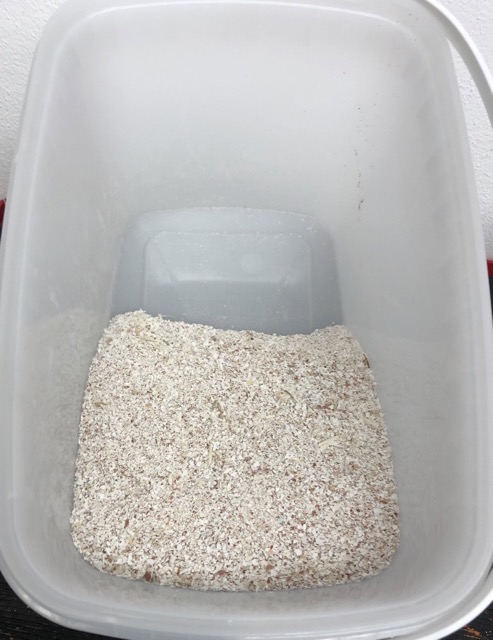 Eierschalenmehl liegt in einem weißen Eimer.