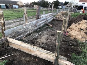 Holzbretter sind an Holzpfosten befestigt.